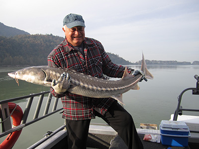 Kevin pictured with an 80-lb White Sturgeon he caught in Canada one year after his first knee replacement
